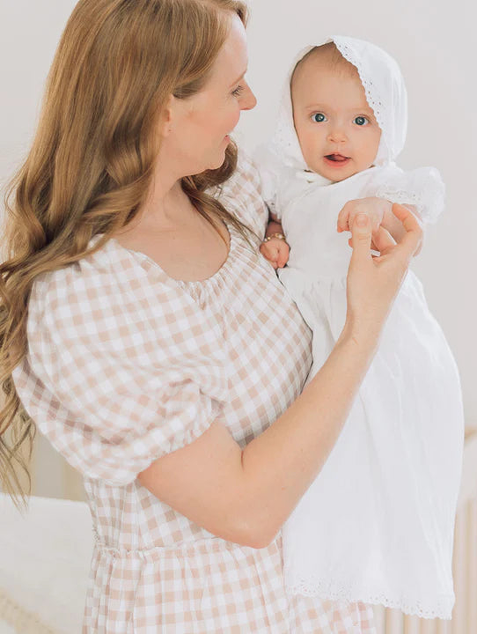 Mother holding baby in white dress